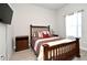 Cozy bedroom features a wood bed frame, bedside table, and a window with sheer curtains at 932 Wild Date Ln, Lake Mary, FL 32746