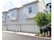 Two-car garages with white doors on a modern townhome, complemented by well-kept landscaping at 932 Wild Date Ln, Lake Mary, FL 32746