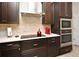 Modern kitchen with dark cabinets, stainless steel appliances, and white countertops at 932 Wild Date Ln, Lake Mary, FL 32746