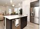 Kitchen island with stainless steel dishwasher and sink, adjacent to the living room and dining area at 932 Wild Date Ln, Lake Mary, FL 32746