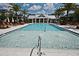 Community pool surrounded by lounge chairs and palm trees, perfect for relaxation at 932 Wild Date Ln, Lake Mary, FL 32746