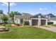 Single-story home features a well-manicured lawn and an attached two-car garage with mature flowering landscaping at 98 Lakepointe Cir, Kissimmee, FL 34743