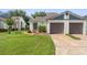 Single-story home features a well-manicured lawn and an attached two-car garage and mature flowering landscaping at 98 Lakepointe Cir, Kissimmee, FL 34743