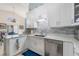 Bright kitchen with white cabinets, stainless steel appliances, tile backsplash, and elegant countertops with modern lighting at 98 Lakepointe Cir, Kissimmee, FL 34743
