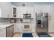 Modern kitchen featuring white cabinets, stainless steel appliances, tile backsplash, and elegant countertops at 98 Lakepointe Cir, Kissimmee, FL 34743