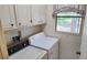 Well-lit laundry area featuring a side-by-side washer and dryer, and upper cabinets for convenient storage at 509 Tivoli Park Dr, Davenport, FL 33897
