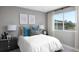 Cozy bedroom with neutral walls, a comfortable bed, and a window offering natural light and neighborhood views at 1007 Wisteria Way, Dundee, FL 33838