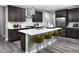 Modern kitchen with gray cabinetry, stainless steel appliances, and a quartz countertop island with bar stool seating at 1007 Wisteria Way, Dundee, FL 33838