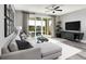 Comfortable living room features a large sectional sofa, entertainment center, and sliding glass doors to the outdoor patio at 1007 Wisteria Way, Dundee, FL 33838
