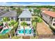 Aerial view of the backyard, pool, and home with palm trees at 1021 Castle Pines Ct, Reunion, FL 34747