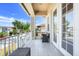 Cozy outdoor seating on a balcony with white railings, tile flooring and a view of neighborhood street at 1021 Castle Pines Ct, Reunion, FL 34747