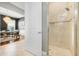 Modern bathroom with tiled walk-in shower and clear glass door, adjacent to a dining area at 1021 Castle Pines Ct, Reunion, FL 34747