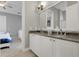 Bathroom featuring a double vanity with granite countertops and access to the bedroom at 1021 Castle Pines Ct, Reunion, FL 34747