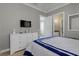 Well-lit bedroom with crown molding featuring a TV, dresser and open doorway at 1021 Castle Pines Ct, Reunion, FL 34747