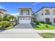 Charming two-story home with a stone facade, balcony, and paver driveway at 1021 Castle Pines Ct, Reunion, FL 34747