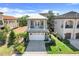 Two-story home with stone accents, a white garage door, a second-story balcony, and manicured landscaping at 1021 Castle Pines Ct, Reunion, FL 34747
