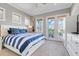 Serene main bedroom with a walk-out balcony, plush carpeting, and stylish furnishings at 1021 Castle Pines Ct, Reunion, FL 34747