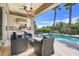 Outdoor kitchen with a built-in grill, seating, and a view of the pool at 1021 Castle Pines Ct, Reunion, FL 34747