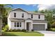 Charming two-story home featuring a two-car garage, manicured lawn, and inviting facade at 1026 Wisteria Way, Dundee, FL 33838
