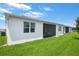 Exterior view of white stucco home with well maintained lawn and a screened-in patio at 1034 Wisteria Way, Dundee, FL 33838