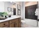 Stylish bathroom featuring a dark tiled shower and wood vanity at 1034 Wisteria Way, Dundee, FL 33838