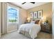 Serene bedroom featuring a large window, neutral color palette, and comfortable furnishings at 1034 Wisteria Way, Dundee, FL 33838