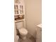 Bathroom featuring white toilet, storage cabinet, and decorative shelf, creating a clean and organized space at 11273 Amber Ridge Dr, Zellwood, FL 32798