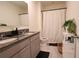 Well-lit bathroom featuring a double vanity with granite countertops and a shower with a white curtain at 11273 Amber Ridge Dr, Zellwood, FL 32798