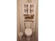 Bathroom featuring white toilet, storage cabinet, and decorative shelf, creating a clean and organized space at 11273 Amber Ridge Dr, Zellwood, FL 32798