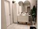 Modern bathroom with a double sink vanity, sleek white cabinetry, and stylish oval mirrors at 11273 Amber Ridge Dr, Zellwood, FL 32798