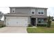 Charming two-story home featuring a two-car garage, well-maintained lawn, and neutral exterior paint at 11273 Amber Ridge Dr, Zellwood, FL 32798