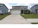 Inviting two-story home with a spacious driveway, two-car garage, and lush green lawn at 11273 Amber Ridge Dr, Zellwood, FL 32798