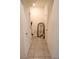 Hallway with neutral walls, decorative mirror, and clean lines, leading to various rooms in the home at 11273 Amber Ridge Dr, Zellwood, FL 32798