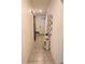 Well-lit hallway featuring a decorative shelf, tiled flooring, and a collage of photos, adding character to the home at 11273 Amber Ridge Dr, Zellwood, FL 32798
