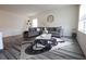 Cozy living room with a gray sectional sofa, area rug, and plenty of natural light at 11273 Amber Ridge Dr, Zellwood, FL 32798