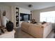 Bright living room featuring custom shelving, a large screen TV, and a comfortable couch, perfect for relaxation at 11273 Amber Ridge Dr, Zellwood, FL 32798