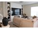 Cozy living room with stylish built-in shelving, large TV, and comfortable couch for relaxing and entertainment at 11273 Amber Ridge Dr, Zellwood, FL 32798