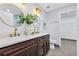 Bright bathroom with double sinks, dark wood cabinets, a white countertop, modern lighting, and gold hardware at 1176 Epson Oaks Way, Orlando, FL 32837