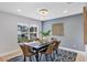 Bright dining room with large windows, decorative wall art, a modern chandelier, and a comfortable dining set at 1176 Epson Oaks Way, Orlando, FL 32837