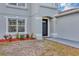 Elegant entryway featuring a black front door, trimmed windows, and decorative landscaping enhancing curb appeal at 1176 Epson Oaks Way, Orlando, FL 32837