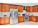 Bright kitchen features stainless steel appliances, white counters, and warm wood cabinetry at 1176 Epson Oaks Way, Orlando, FL 32837