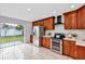 Bright kitchen features stainless steel appliances, white counters, warm wood cabinetry, and backyard views at 1176 Epson Oaks Way, Orlando, FL 32837
