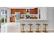 Bright kitchen features stainless steel appliances, white counters, an island with seating, and warm wood cabinetry at 1176 Epson Oaks Way, Orlando, FL 32837