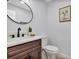Chic powder room features updated fixtures and a modern round mirror at 1176 Epson Oaks Way, Orlando, FL 32837