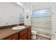 Standard bathroom featuring a single sink vanity with wood cabinets and a shower-tub combo with curtain at 1306 Harbor Ridge Dr, Kissimmee, FL 34759