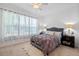 Cozy bedroom featuring carpet floors, soft lighting, and a large window with decorative sheer curtains at 1306 Harbor Ridge Dr, Kissimmee, FL 34759