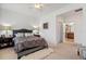 Warm bedroom with carpeted floors, large bed, and access to a spacious bathroom with double sinks at 1306 Harbor Ridge Dr, Kissimmee, FL 34759