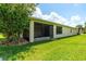 Screened-in lanai of home featuring lush landscaping, green lawn and sun-drenched exterior at 1306 Harbor Ridge Dr, Kissimmee, FL 34759