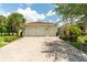 Charming home with a three car garage and brick paved driveway, surrounded by landscaping at 1306 Harbor Ridge Dr, Kissimmee, FL 34759