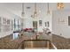 Modern kitchen featuring granite countertops, a stainless steel sink, and an open view to the living area at 1306 Harbor Ridge Dr, Kissimmee, FL 34759